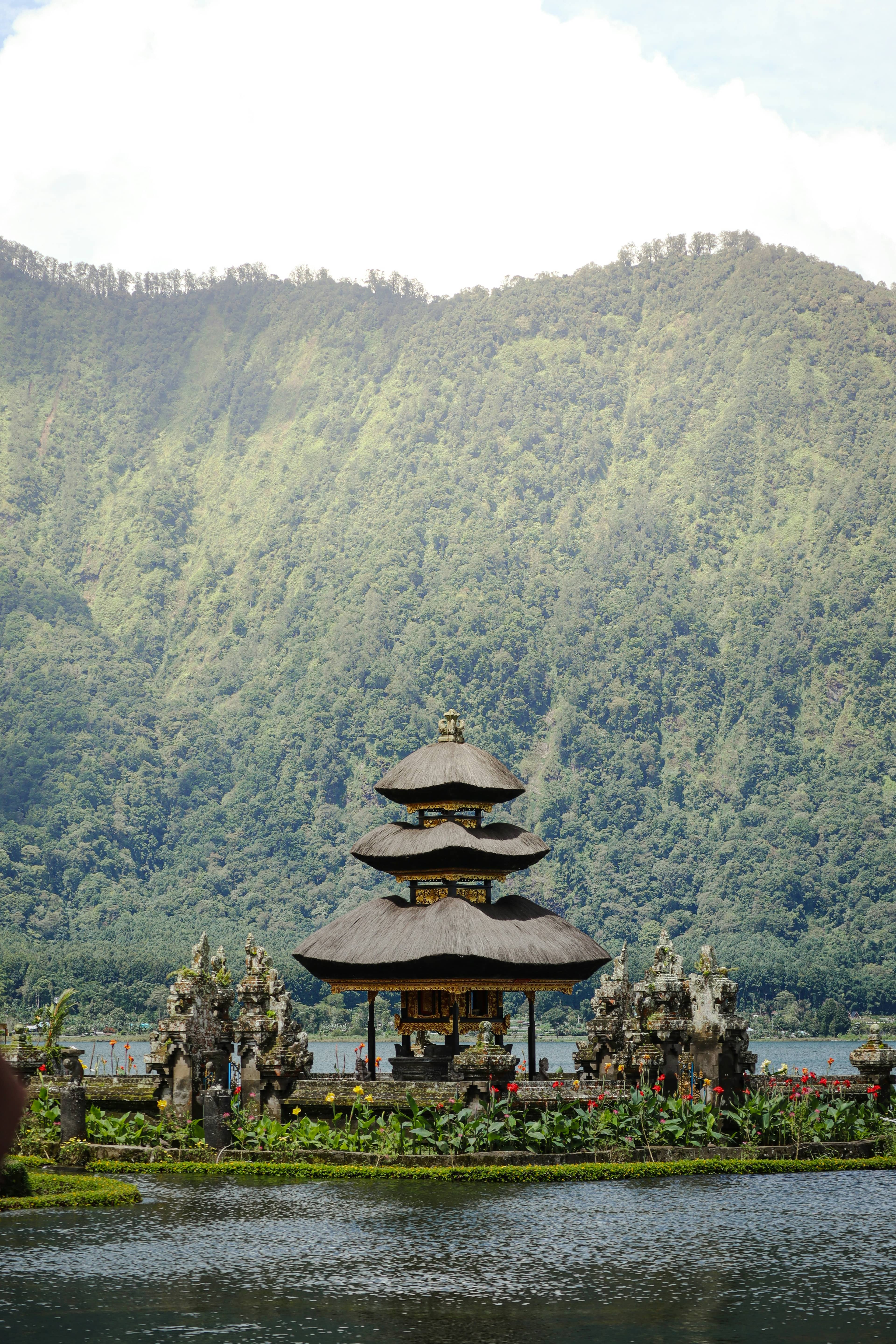 Pura Ulun Danu Beratan lake temple, Bedugul, Bali, pagoda reflected in still water with mountains behind
