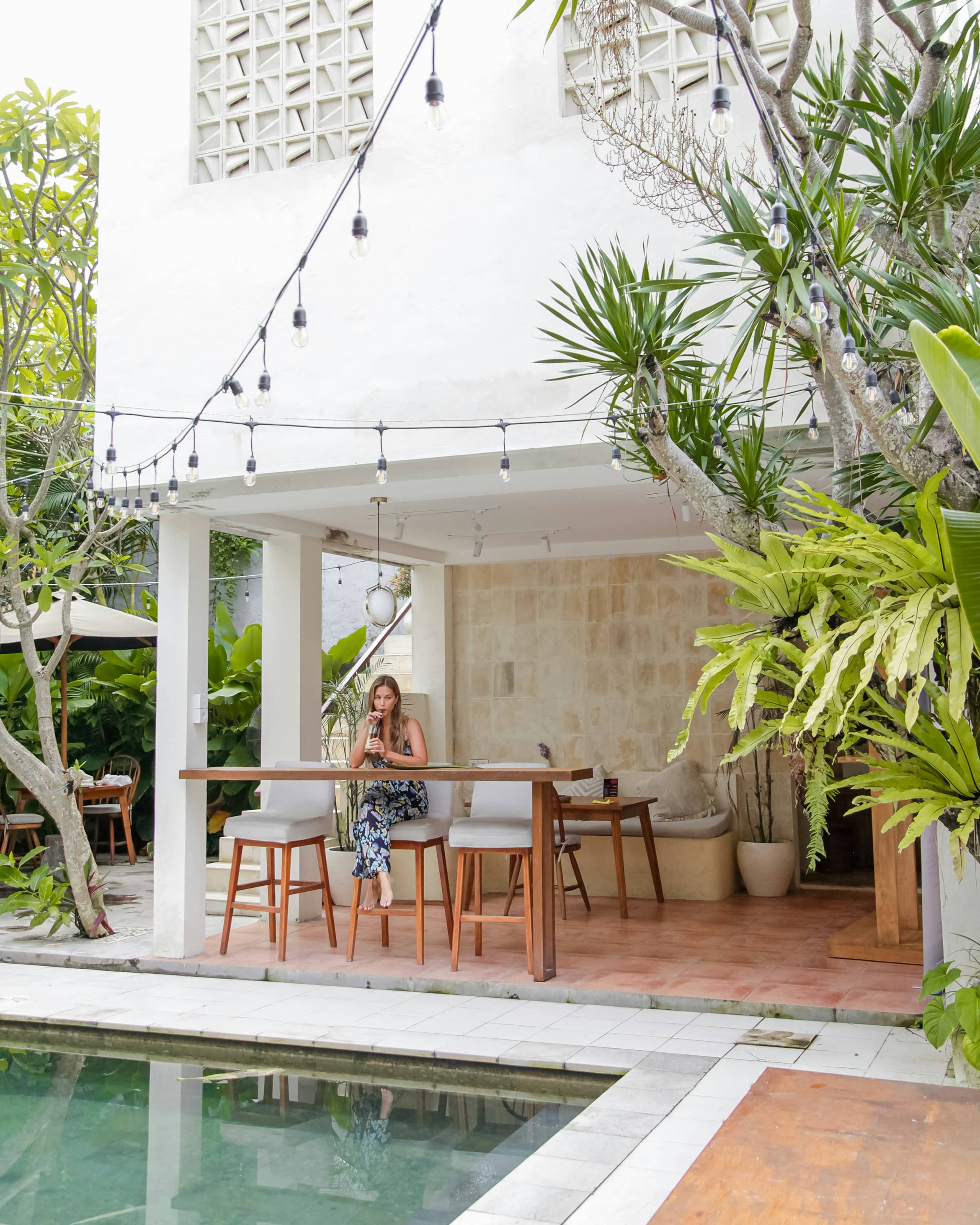 A woman at a spa venue table beside a pool, Canggu, Badung Regency, Bali